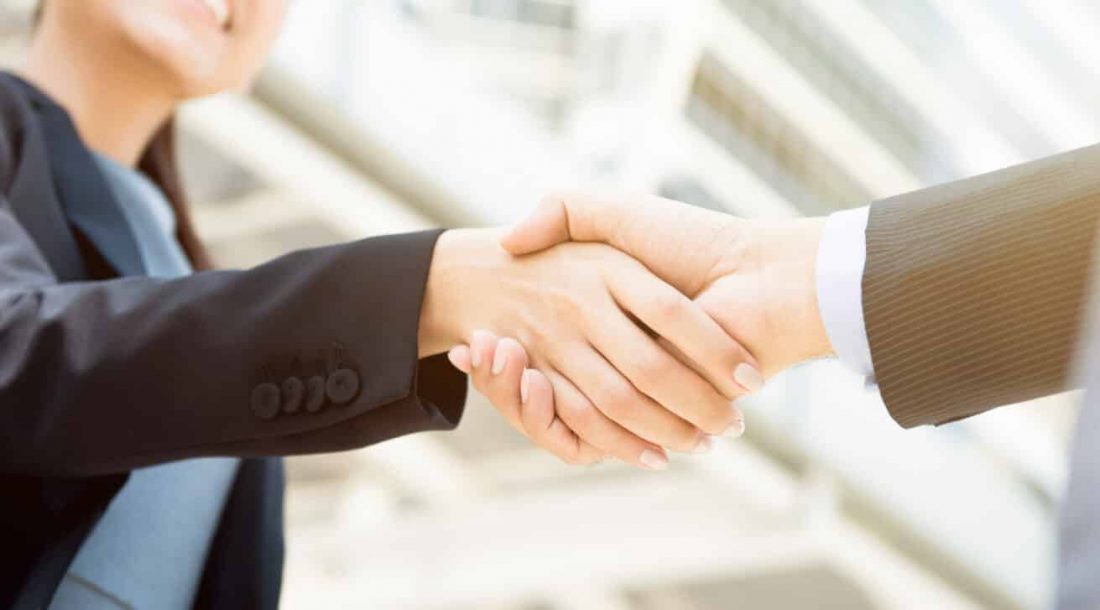 Businesswoman making handshake with a businessman, female leader concept - panoramic web banner